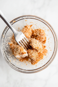 This image shows individual chicken pieces being coated with the dry mixture.