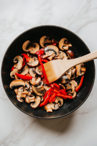 mushrooms-and-red-pepper being tossed in butter