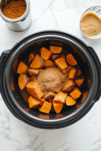 sprinkle-brown-sugar-over-the-sweet-potatoes-and-butter-in-crockpot to make it a little sweet