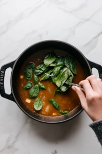 adding-spinach-to-the-simmering pot of broth