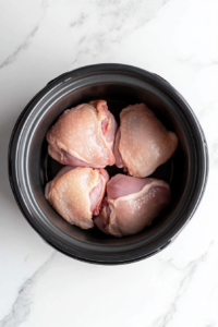 Raw chicken breasts placed into the slow cooker, ready to be transformed into flavorful Crockpot BBQ Chicken.