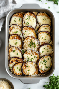 This image shows the final layer of cheese and sauce being added to the Keto Eggplant Lasagna, ready for baking.