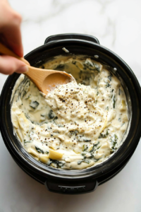 This step involves tasting the cooked spinach artichoke dip and adjusting the seasoning with salt, pepper, or other spices to enhance its flavor.