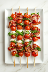 This image shows assembled Caprese salad skewers neatly arranged on a round white platter, ready to be drizzled with pesto dressing.