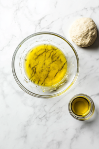 This image shows oil being brushed over the dough to keep it moist as it rises.