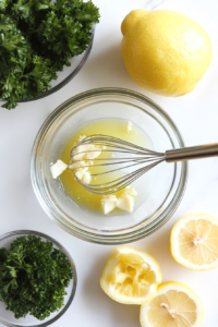 This image captures the preparation of a lemon butter sauce in a small bowl, made with melted butter, fresh lemon juice, garlic, and herbs, ready to brush onto the skewers.