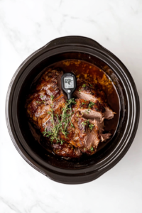 This image shows a meat thermometer inserted into the pork, ensuring it has reached the perfect internal temperature for shredding.