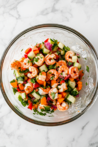 this image shows A covered bowl of shrimp ceviche being refrigerated to enhance flavors and ensure freshness.