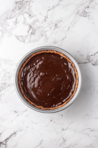 This image shows the prepared vegan chocolate tart being placed in the refrigerator, allowing the smooth chocolate filling to set firmly.