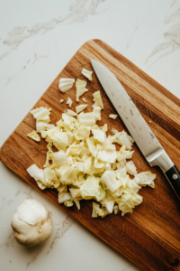 This image shows fresh cabbage being chopped into smaller pieces on a cutting board, ready for the next step in the keto cabbage rice recipe.