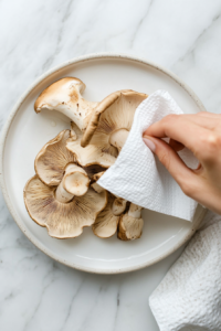 cleaning-oyster-mushrooms-with-a-paper-towel-for-vegan-fried-chicken