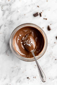 This image shows the chocolate mixture being whisked with vanilla extract and salt, forming a silky and flavorful filling for the vegan tart.