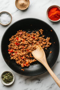 This image shows ground turkey being cooked in a pan until browned and fully cooked, ready to be added to the lasagna sauce.