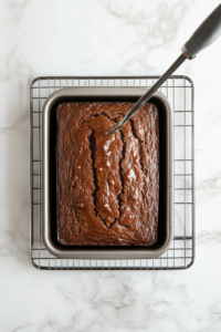 This image shows the baked loaf of Jamaican banana bread resting on a cooling rack, allowing it to cool evenly before slicing.