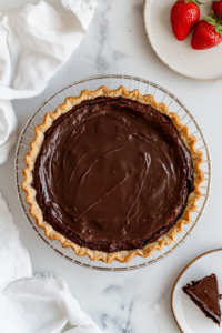 This image shows a freshly baked vegan brownie pie resting on a cooling rack, allowing it to set properly before slicing and serving.