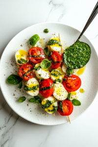 This image shows vibrant green pesto being drizzled generously over the Caprese salad skewers, adding a rich and aromatic layer to the appetizer.