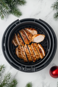 This image shows chicken cutlets being flipped in the air fryer basket to ensure even cooking and a consistent texture on both sides.