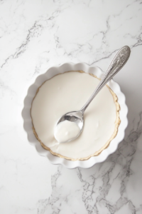 This image shows the crust mixture being pressed into a round tart pan, creating a smooth and even base for the vegan chocolate tart.