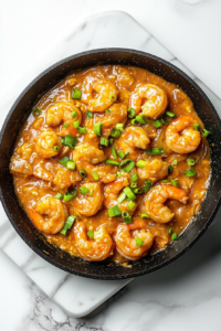 This image shows perfectly cooked shrimp coated with honey mustard garlic sauce in the skillet, ready to be served for a delicious meal.