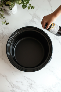 This image shows a crockpot being prepared by lightly greasing the surface to prevent sticking while cooking the lasagna.