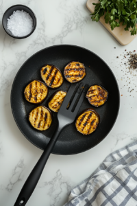 This image shows sliced eggplant being grilled to a tender, golden-brown texture, ready to layer in the lasagna.