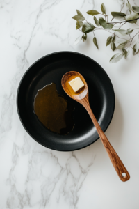 This image shows a hot skillet with melted butter and oil, preparing the base for cooking garlic butter shrimp and broccoli, with a golden glistening surface.