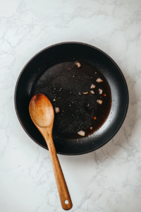 this image shows A skillet with hot oil sizzling diced onions, beginning the cooking process for a rich and creamy vegan mushroom stroganoff.