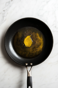 This image shows oil being heated in a skillet, ready for sautéing vegetables for the Keto Turkey Casserole.