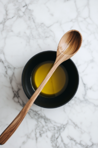 This image shows olive oil being heated in a large pan, shimmering and ready to sauté vegetables for preparing Crockpot Vegetable Soup.