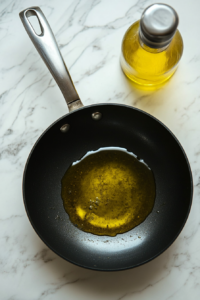 this image shows skillet with shimmering hot olive oil, ready for searing Cajun-seasoned shrimp to perfection for a Keto Caesar Salad.