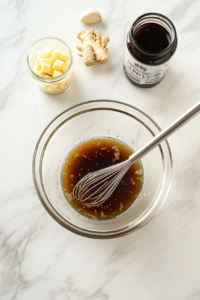 This image shows the preparation of a flavorful honey garlic marinade in a mixing bowl, blending ingredients like honey, soy sauce, garlic, and spices for a perfect shrimp dish.