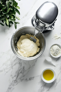 This image shows the smooth, kneaded dough being placed into the oiled bowl, ready to rise.