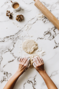 This image shows hands kneading the dough thoroughly on a floured surface to build the structure for the vegan chicken.