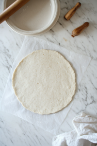 This image shows pastry dough neatly pressed into a pie dish and edges trimmed, with the crust being baked until golden brown.