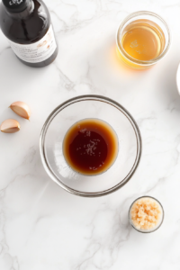 This image shows a bowl of prepared honey garlic marinade set aside, ready to be used for marinating and cooking shrimp.