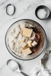 This image shows the almond butter-based crust mixture being evenly pressed into a pie pan, forming the foundation for the vegan and gluten-free pumpkin pie.