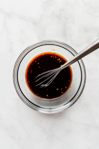 This image shows a dressing being prepared, likely with ingredients like mayonnaise or lemon juice, to complement the fresh ingredients of the kani salad.