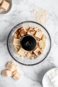 This image shows the process of mixing gluten-free flour, cold vegan butter, cane sugar, dairy-free milk, and sea salt in a bowl to create the dough for the vegan brownie pie crust.