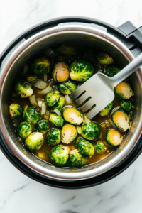 This image shows the Instant Pot lid being opened, and Brussels sprouts are stirred for a final mix before serving.