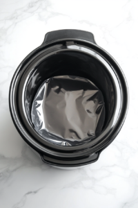 A slow cooker with a liner being properly placed to ensure a mess-free cooking experience for chicken fajitas.