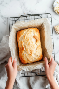 This image shows the loaf of no yeast bread resting on a wire cooling rack, allowing air to circulate and prevent the crust from becoming soggy.