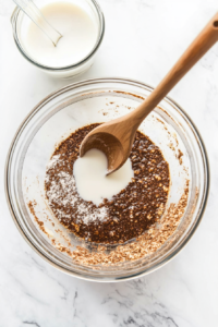 This image shows oil and milk being poured into the bowl of dry ingredients, ready to be mixed into a batter.