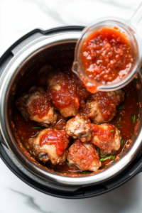 vibrant jar of salsa being poured over seasoned chicken breasts inside an Instant Pot, adding a tangy and spicy layer of flavor to the keto chicken recipe.