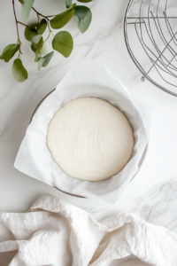 This image shows an oven being preheated and a round pie dish being prepared with a raw crust, ready for baking.