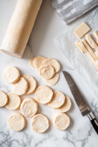 This image shows biscuit dough being rolled and sliced into strips, ready to be added to the crockpot for a soft and flaky topping for the chicken and dumplings.