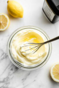 this image shows small bowl with creamy keto coleslaw dressing being whisked together, featuring ingredients like mayonnaise, vinegar, and seasonings for a tangy, low-carb flavor.