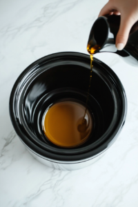 This image shows a slow cooker being prepared for Crockpot Orange Chicken, with a clean and empty interior ready for the ingredients.