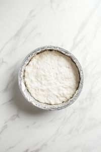 This image shows the pastry dough being pressed into the tart pan, ready to be pre-baked, forming the crust for the Vegan Treacle Tart.