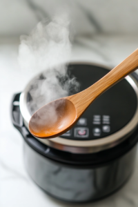 close-up view of the Instant Pot’s valve being carefully turned to release steam after cooking the keto chicken, ensuring safety and proper cooking.