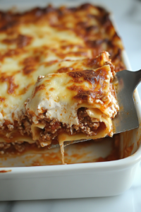 This image features a freshly baked vegan lasagna bolognese resting in a dish, with its layers perfectly set, ready to be sliced and served.